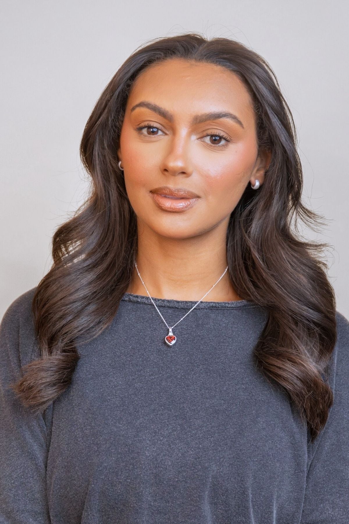 model wears Garnet Heart in Hand Silver Charm Necklace
