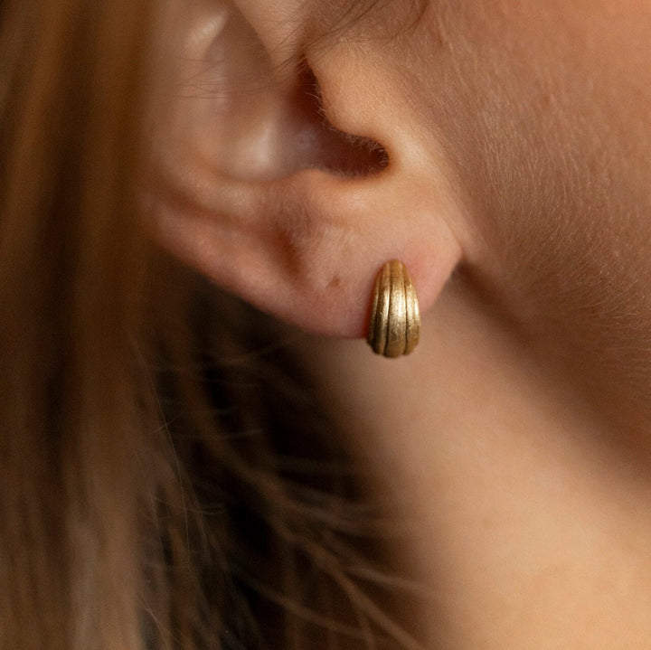 model wears chunky 18k gold vermeil ridged huggie hoop earrings