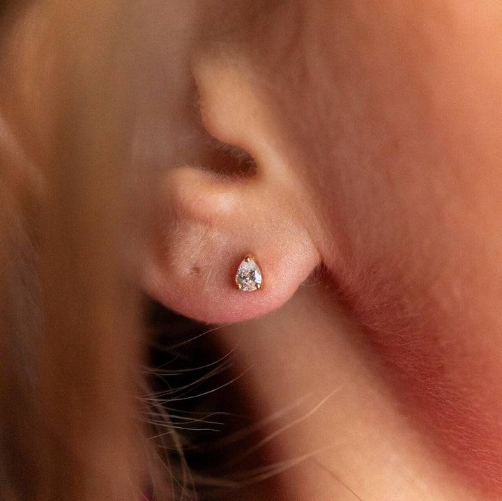 model wears pear stud earrings