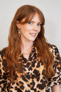 model wears emerald gold chandelier ear jacket earrings and gold belcher rolo 
necklace