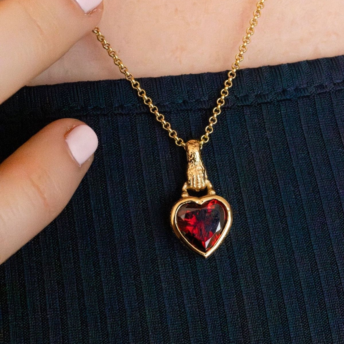 model wears garnet hand in heart gold charm necklace