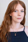 model wears garnet hand in heart gold charm necklace 
