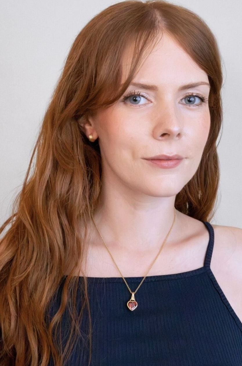 model wears garnet hand in heart gold charm necklace 