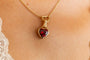model wears garnet hand in heart gold charm necklace on heart connector