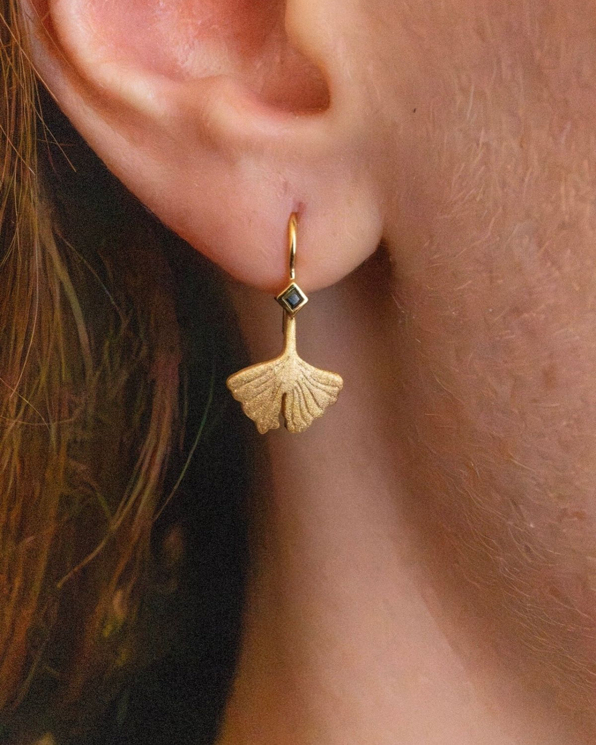 model wears Ginkgo Leaf Gold Earrings close up
