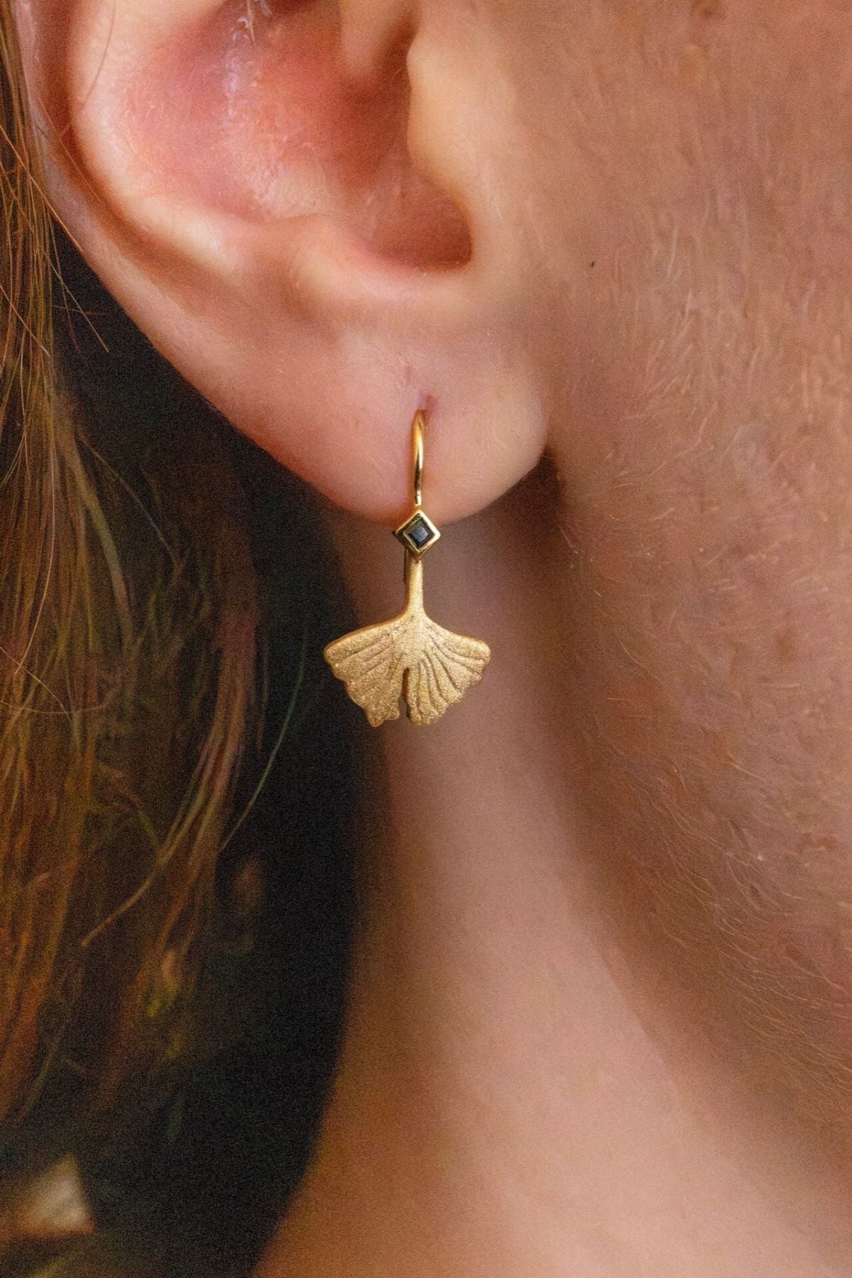 model wears Ginkgo Leaf Gold Earrings close up
