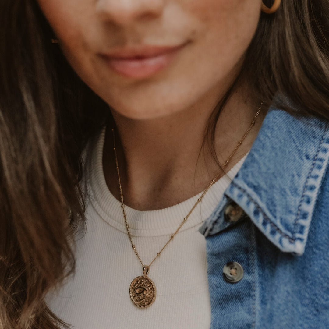 model wears “Fuck” Gold Shorthand Coin Necklace