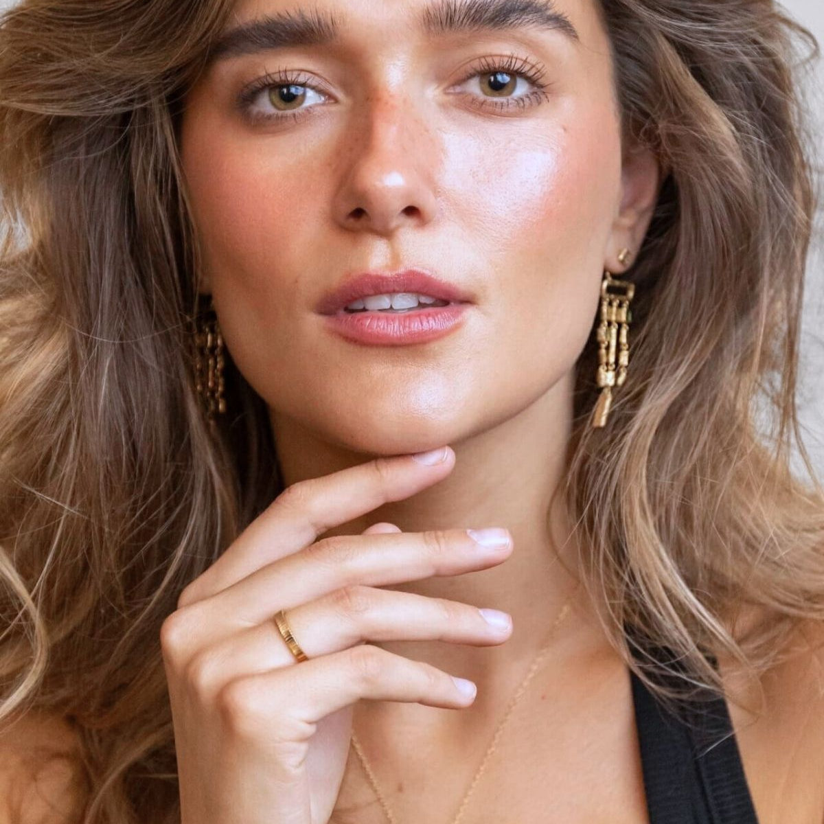 model wears lovespoon gold necklace and emerald ear jacket earrings
