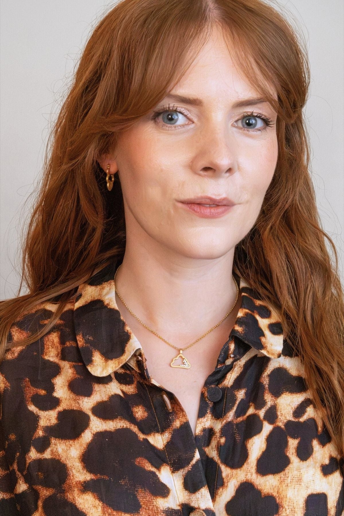 model wears gold sparkly cloud hoop earring and sparkly gold cloud necklace
