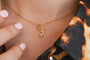 model wears great gold shorthand pendant on dainty gold chain
