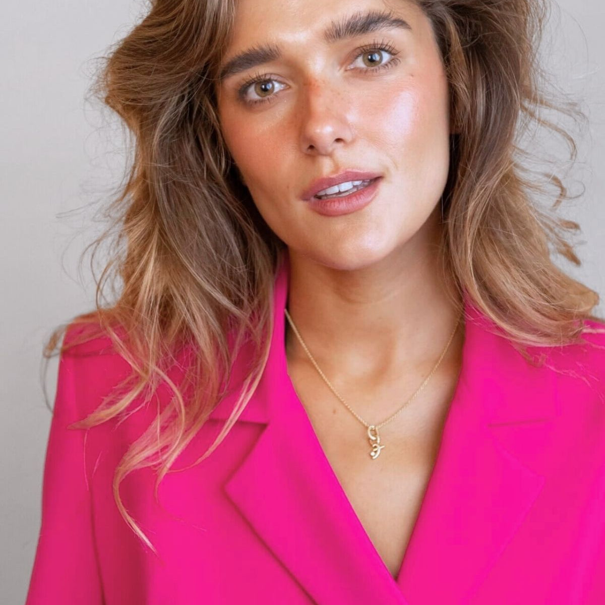 model wears great gold shorthand pendant on oval connector 
