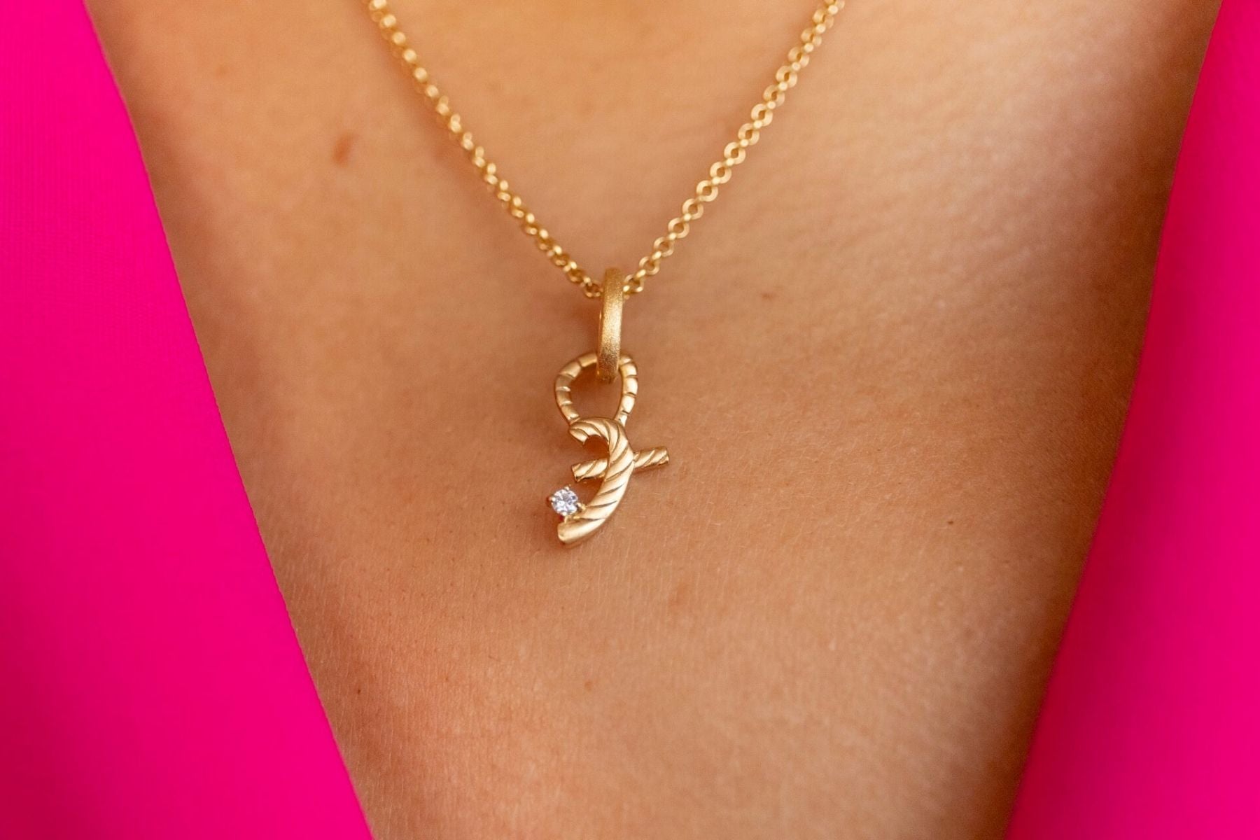 model wears great gold shorthand pendant on oval connector  close up
