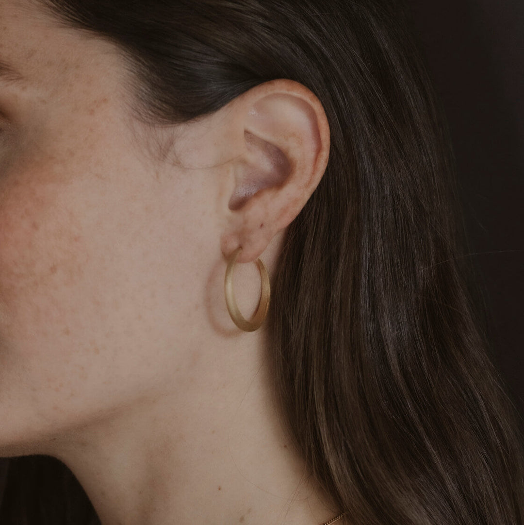 Model wears large 30mm gold vermeil brushed hoop earrings