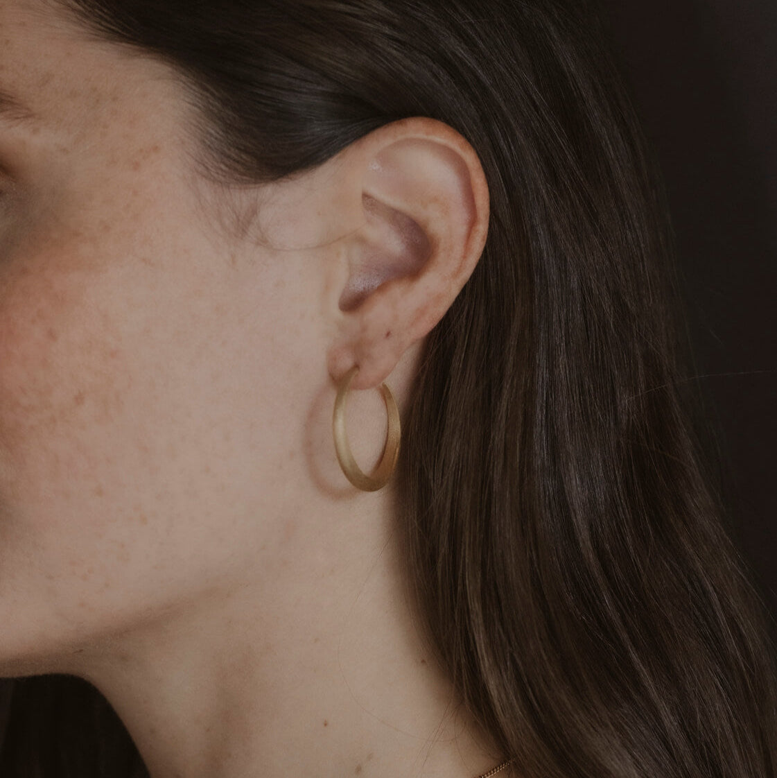 Model wears large 30mm gold vermeil brushed hoop earrings