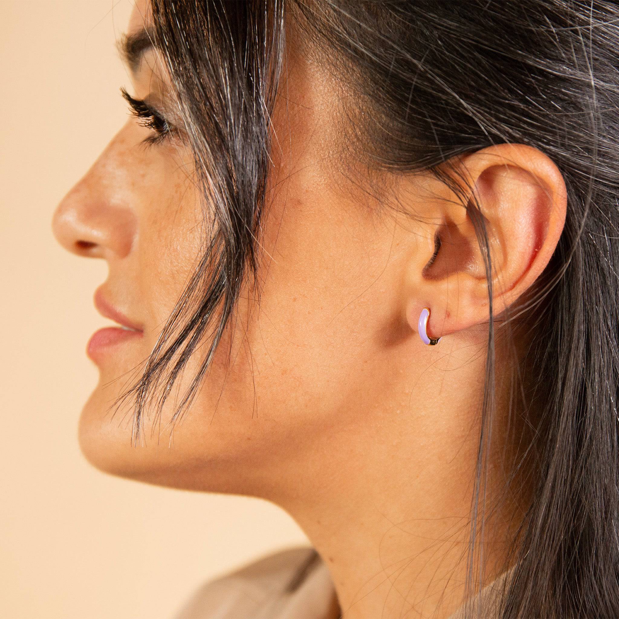 model wears Lavender Enamel Gold Huggie Earrings