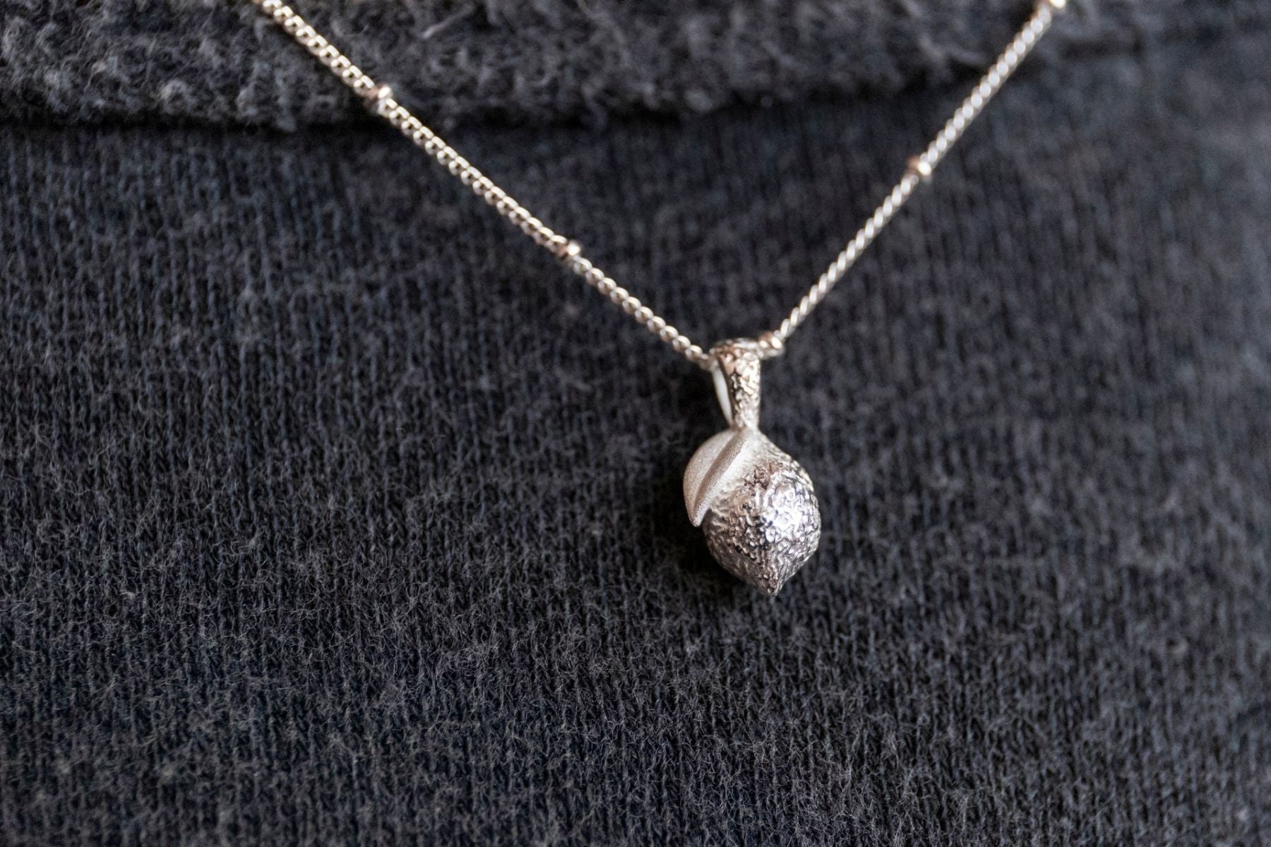 model wears silver lemon charm necklace
