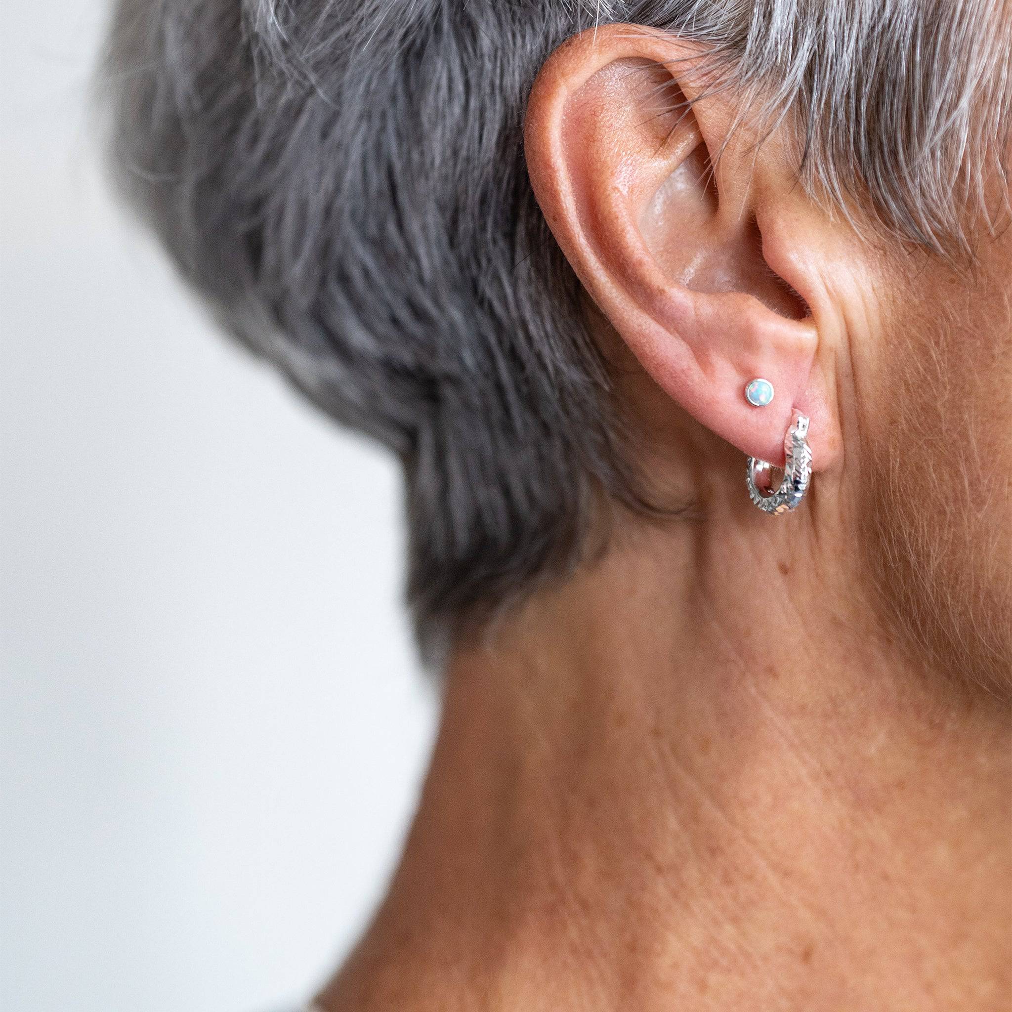model wears Moon Yellow Opal Silver Stud Earrings and silver diamond cut hoop earrings