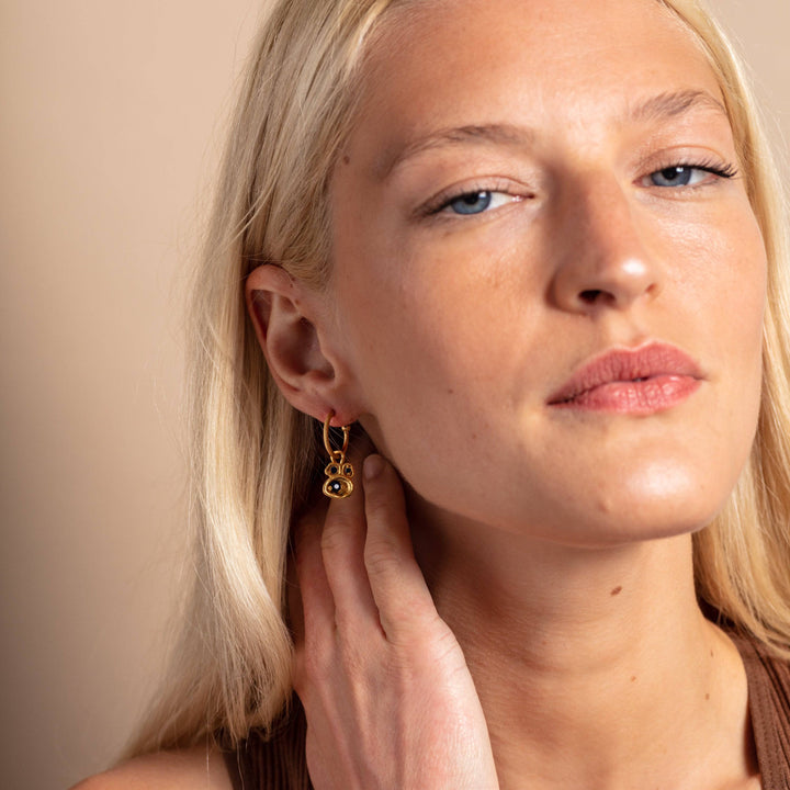 model wears Blue Sapphire and Gold Lichen Birthstone Hoop Earrings