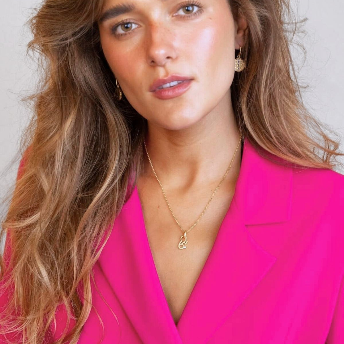 model wears sapphire gold coin drop earrings and brave gold necklace