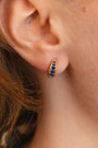 model wears sapphire huggie hoop gold earrings