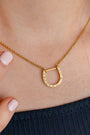 model wears shorthand gold horseshoe charm connector necklace