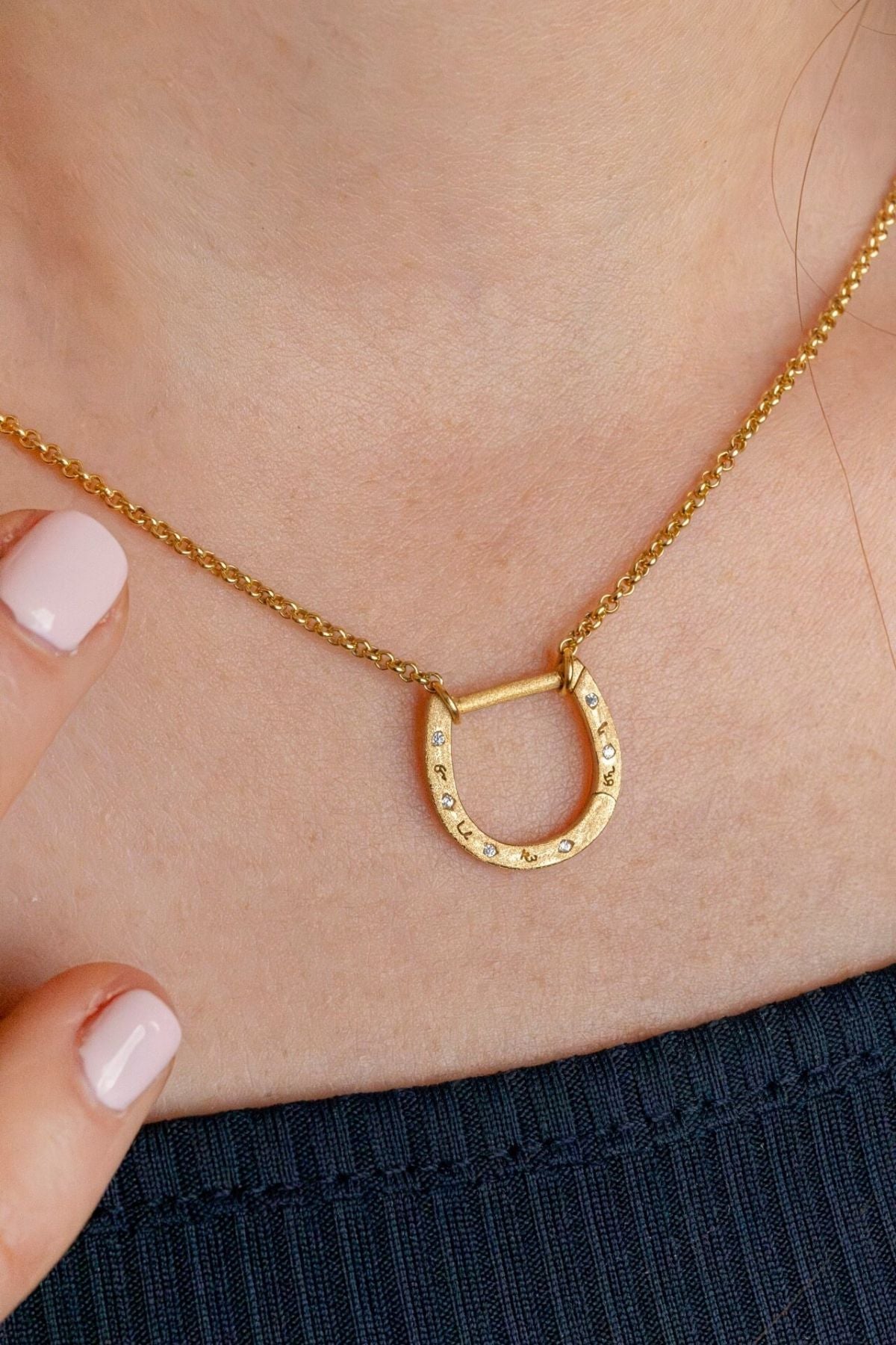 model wears shorthand gold horseshoe charm connector necklace