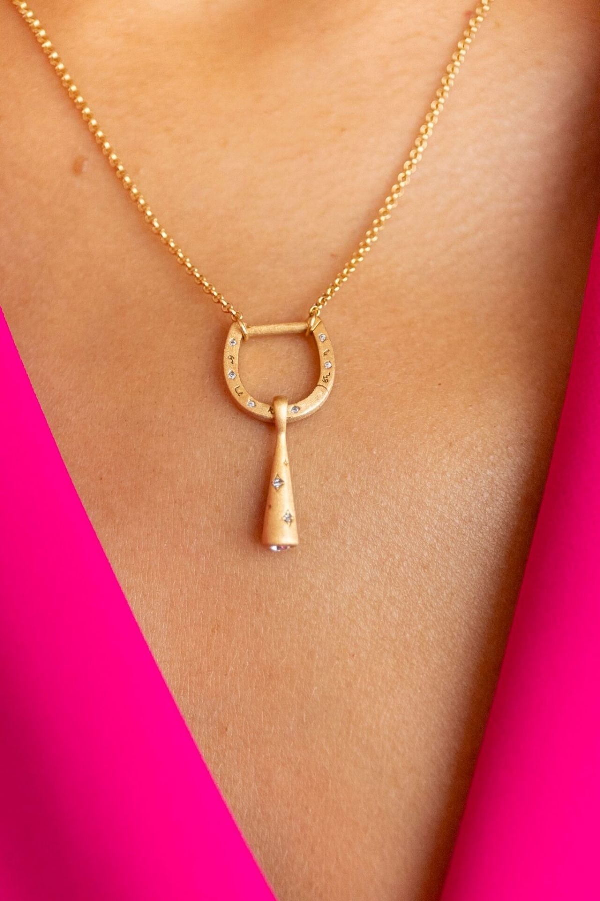 model wears shorthand gold horseshoe charm connector necklace
