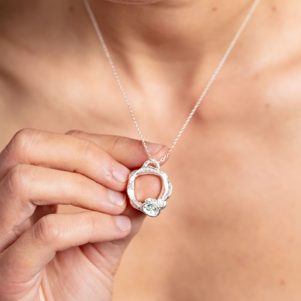 model-wears-silver-aquamarine-brirthstone-small-branch-eternity-necklace-claire-hill-designs-close-up