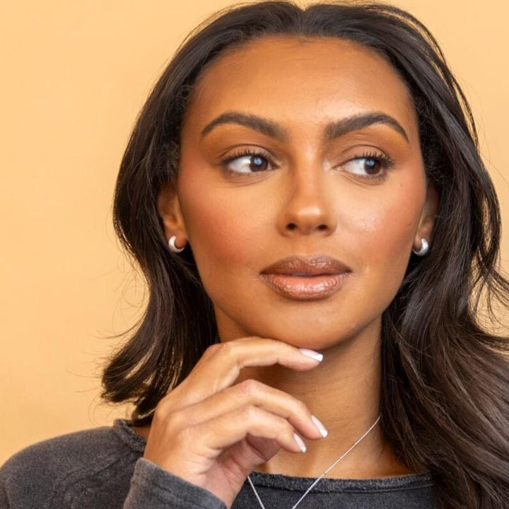 model wears chunky silver huggie hoop earrings