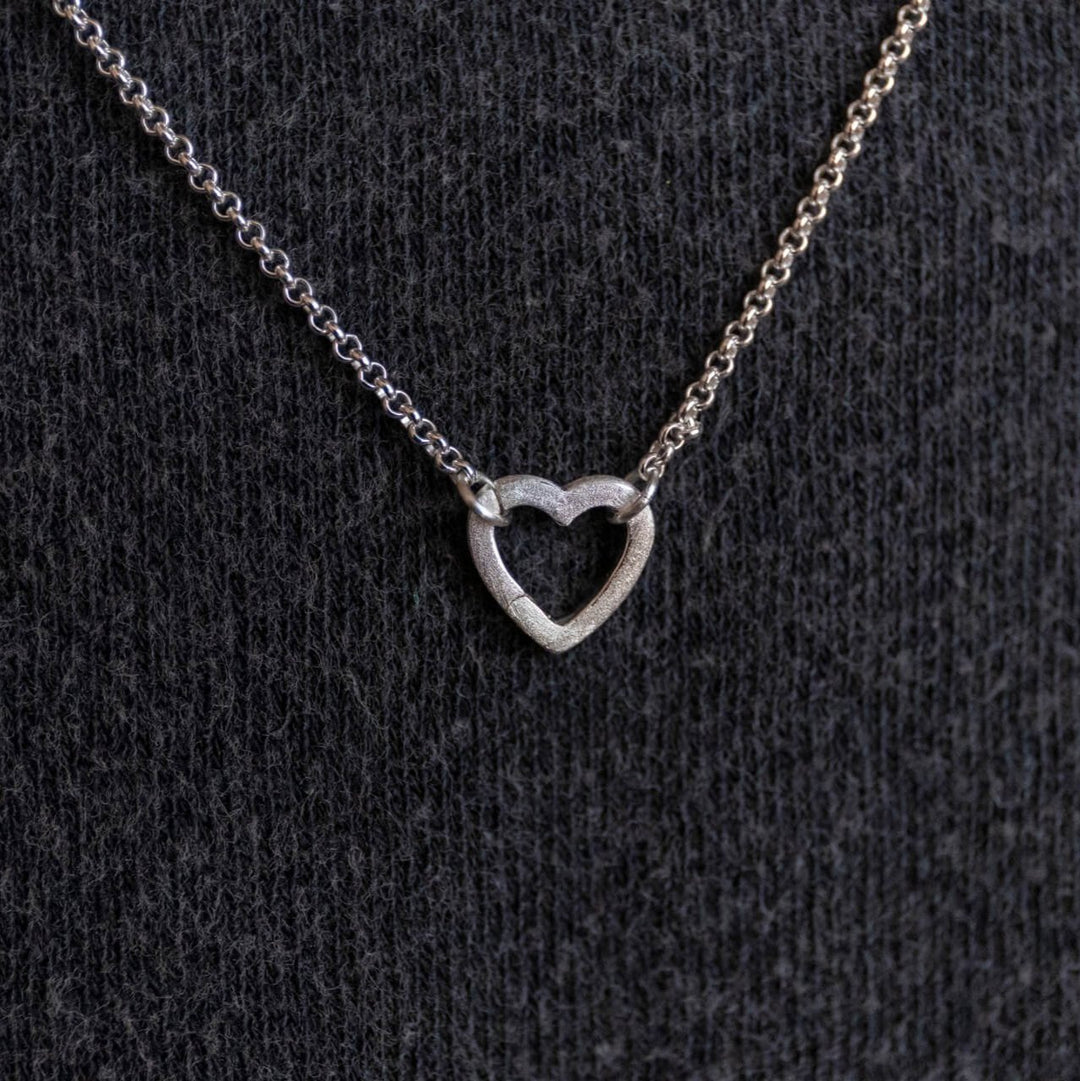 model wears silver brushed heart connector necklace on rolo chain - Claire Hill Designs