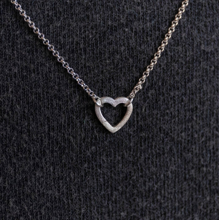 model wears silver brushed heart connector necklace on rolo chain - Claire Hill Designs