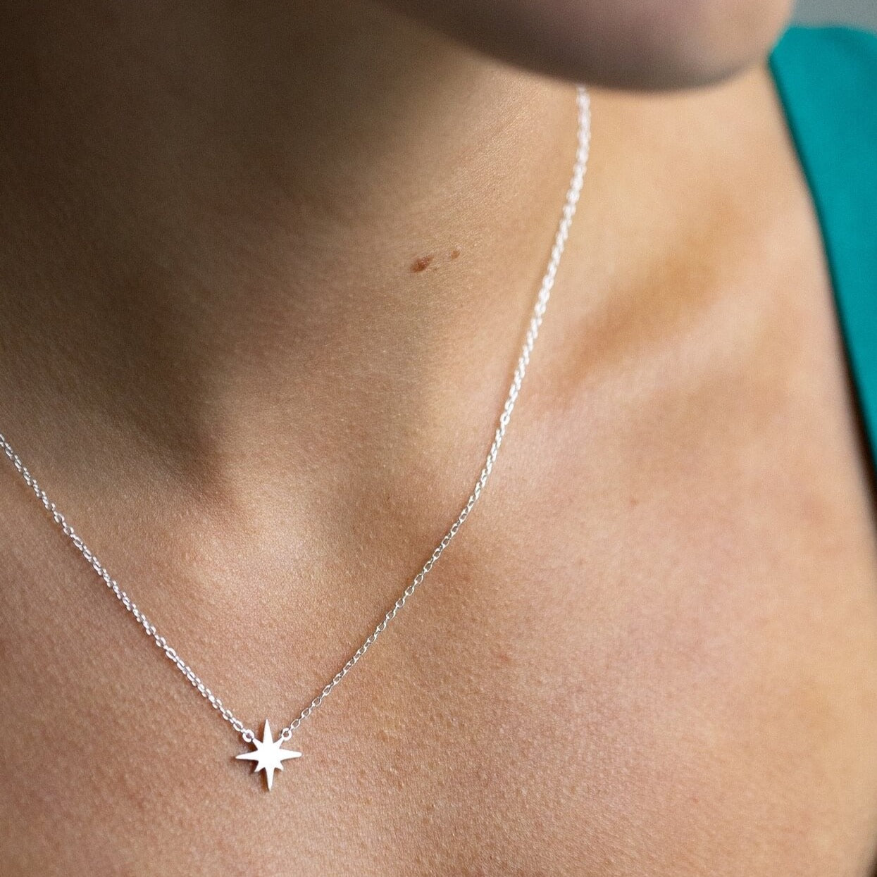 model wears silver brushed north star dainty necklace