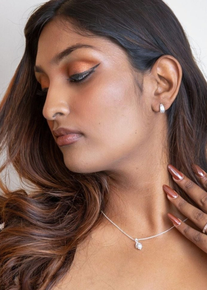 model wears Brushed Silver Chunky Huggie Hoops