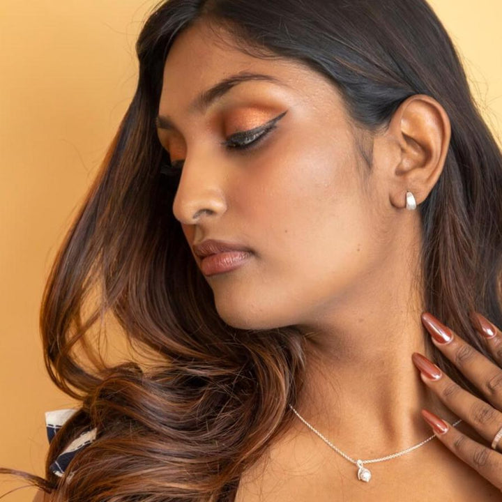 model wears chunky silver huggie hoop earrings