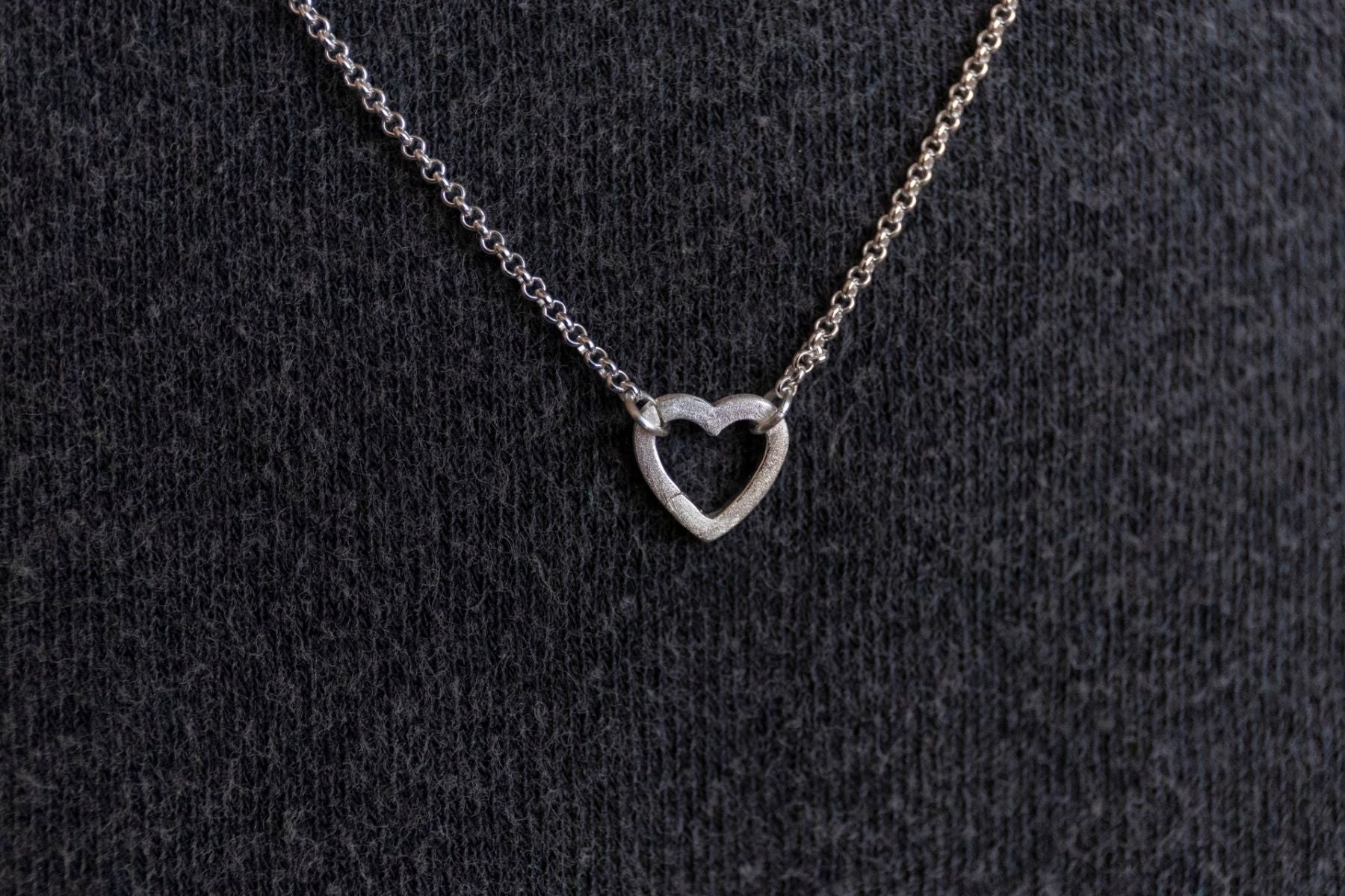 model wears brushed silver heart connector necklace 