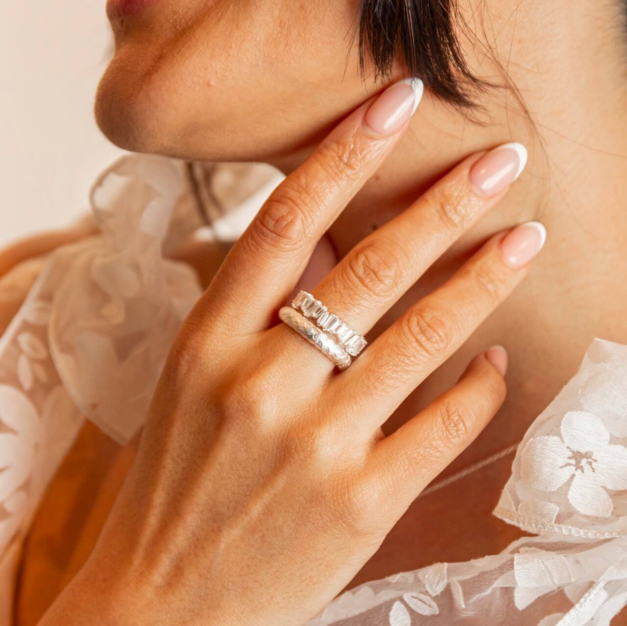 Model wears sparkly silver eternity ring and silver lab grown diamond ring