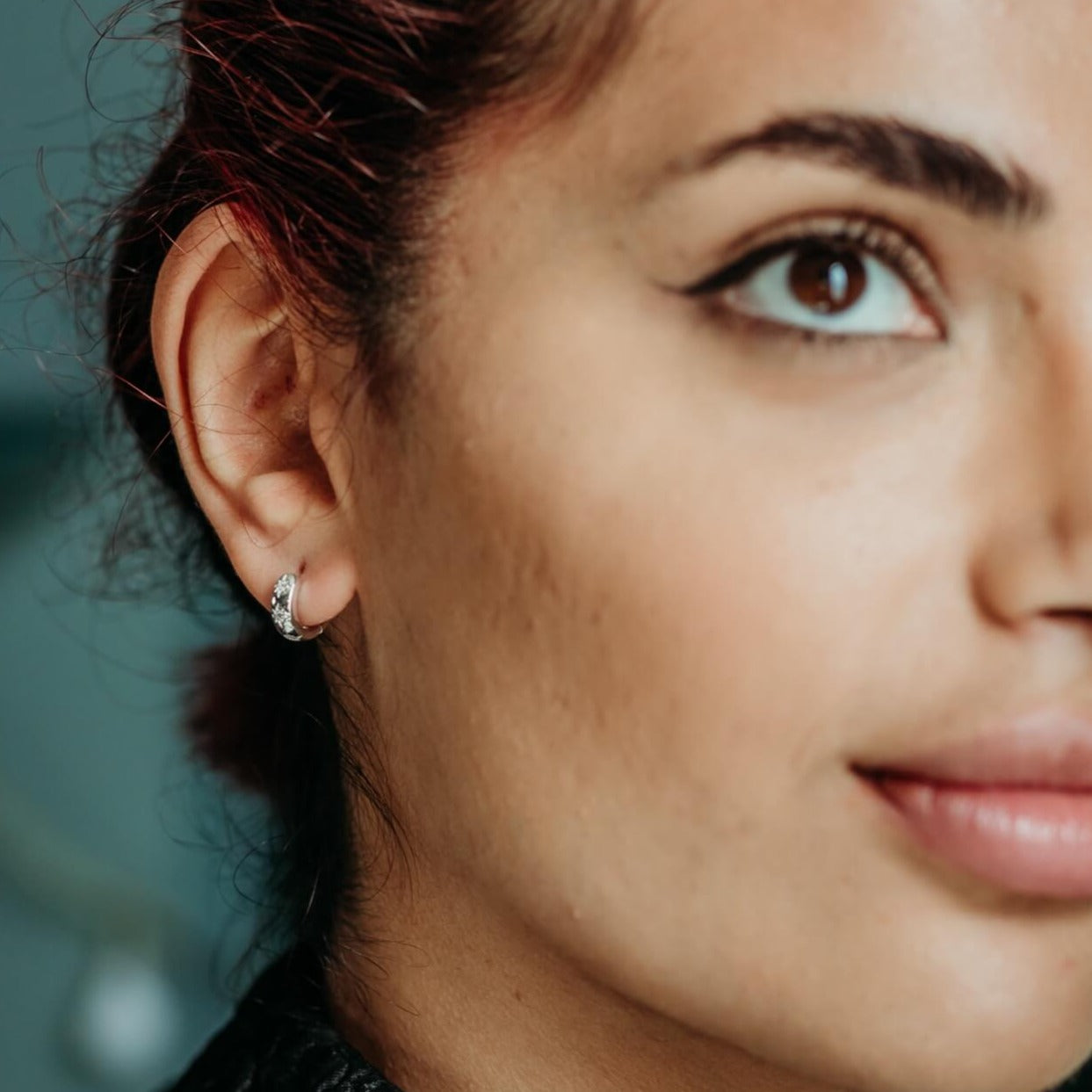 model wears Silver Sparkly Star Huggie Hoop Earrings