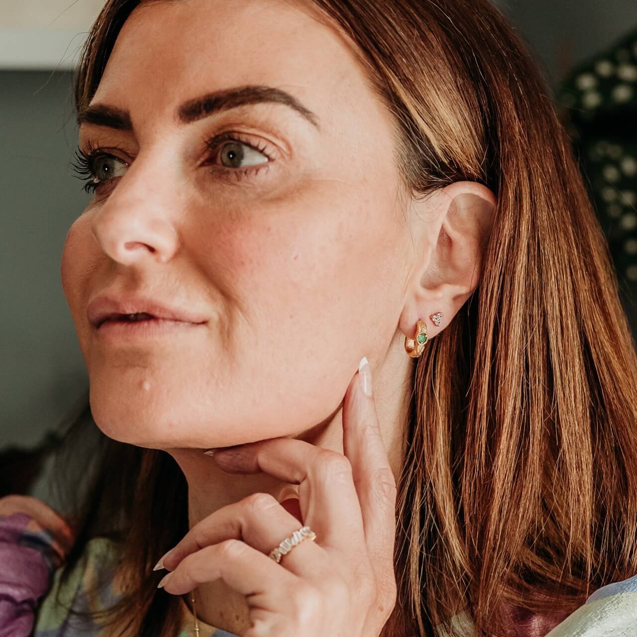 Model wears Triple Sparkly Gold Mini Stud Earrings and Emerald Gold Hoop Earrings