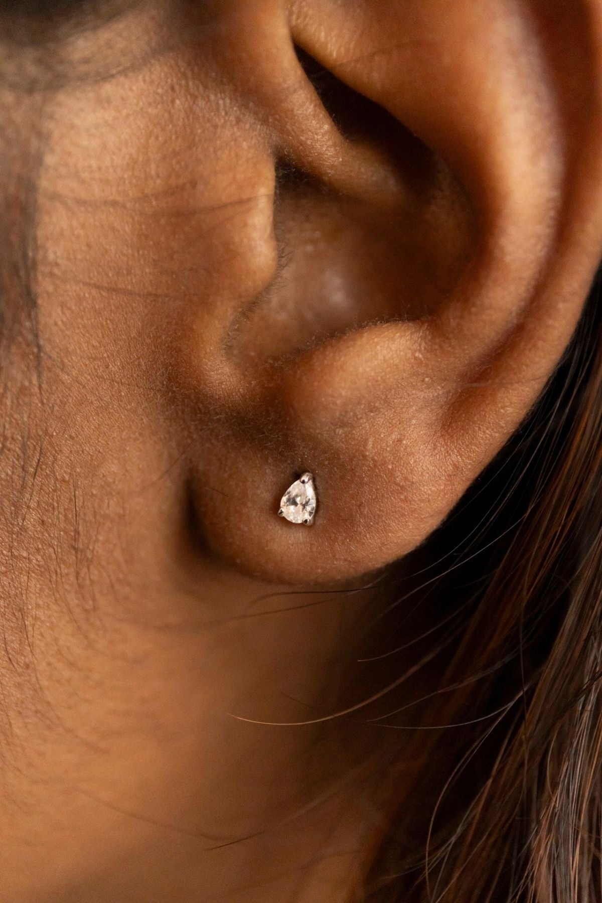 model wears silver ear jacket earrings studs 
