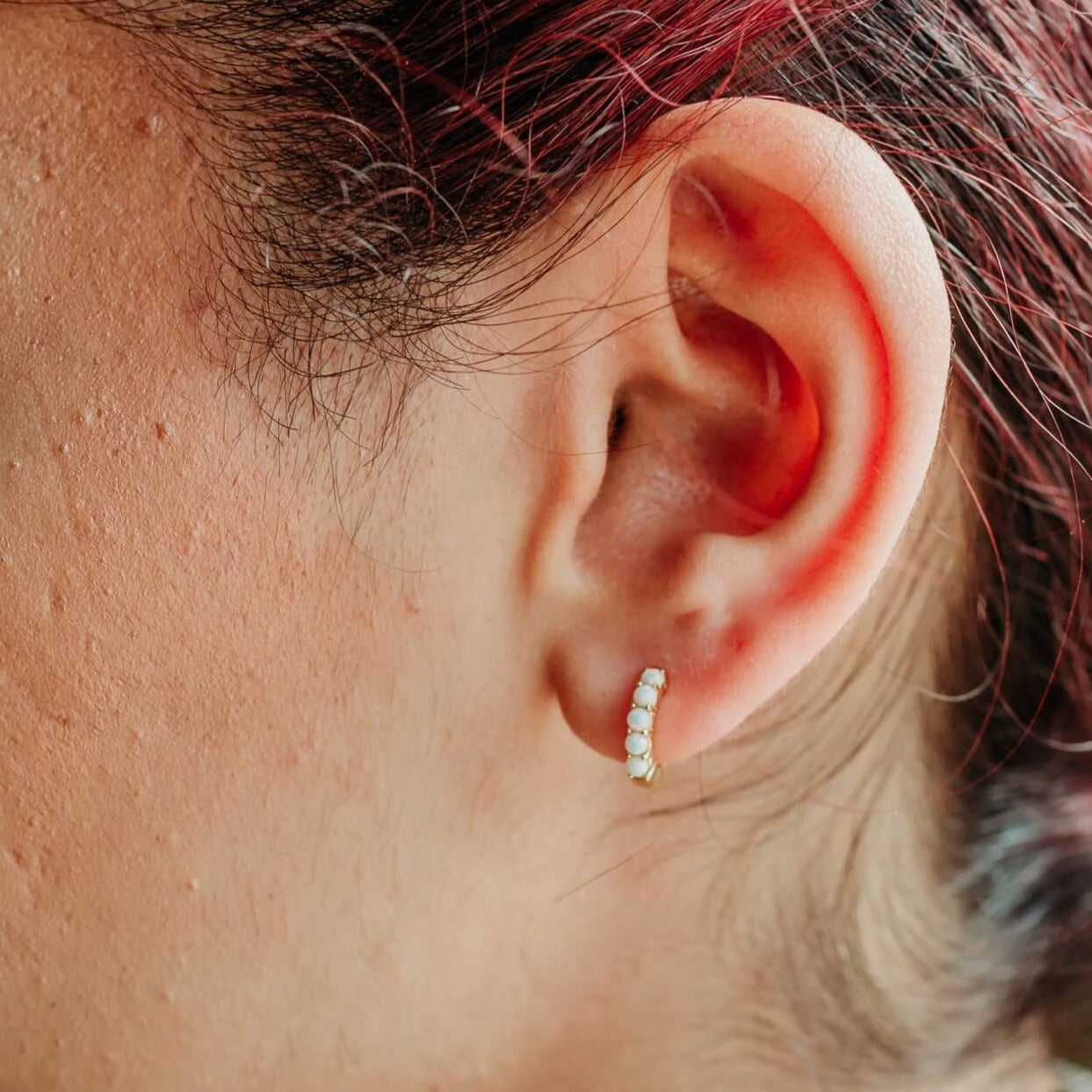 model wears White Opal and Gold Vermeil Huggies - close up
