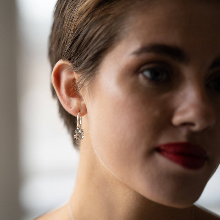 model wears White Topaz and Silver Lichen Birthstone Hoop Earrings close up