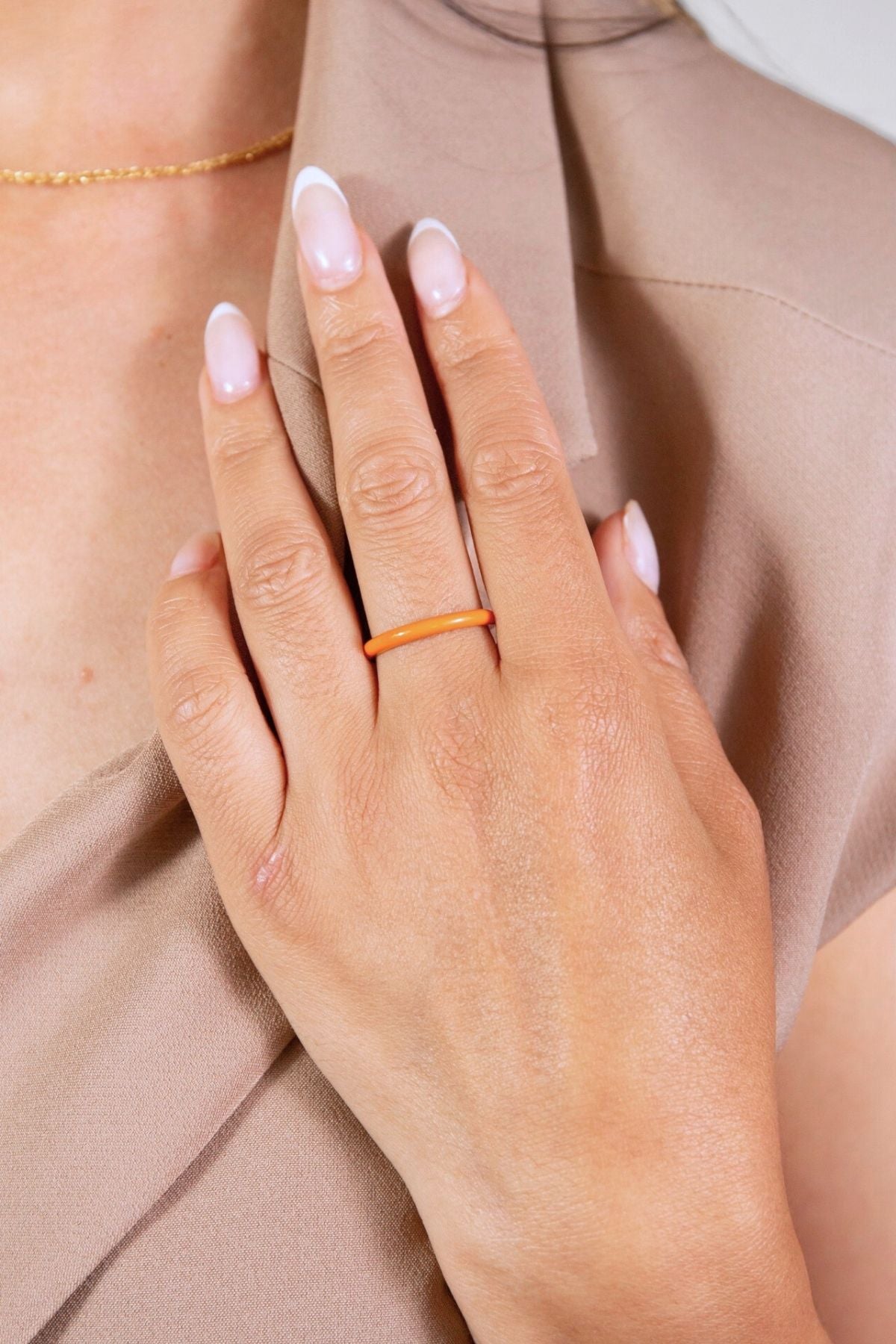 model wears coral enamel ring