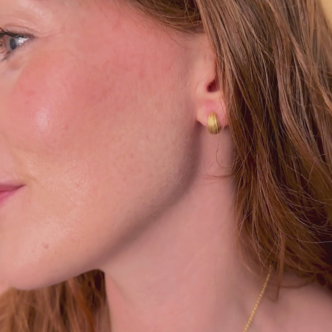 model wears chunky 18k gold vermeil ridged huggie hoop earrings
