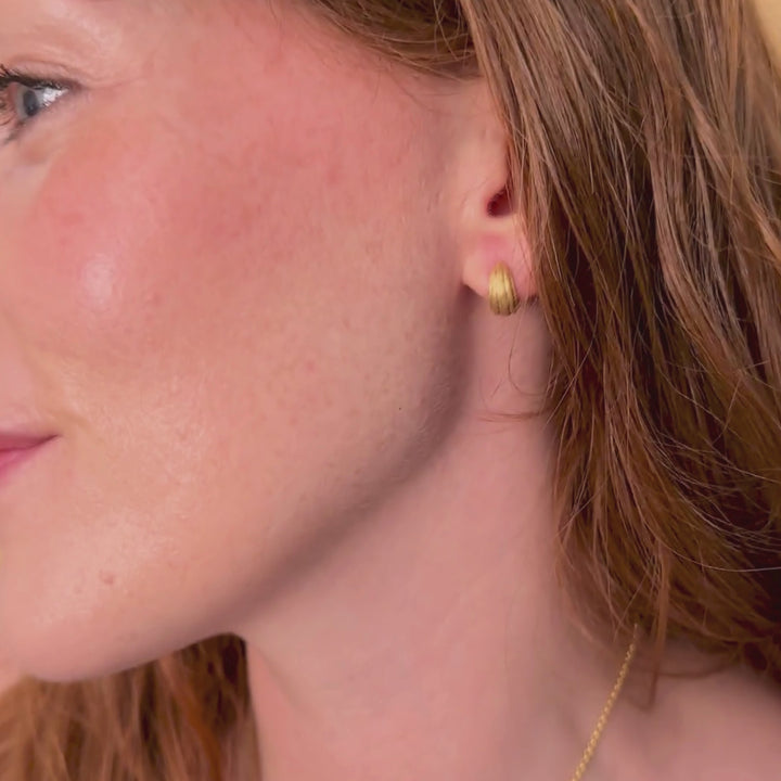 model wears chunky 18k gold vermeil ridged huggie hoop earrings
