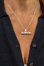 Close up of woman wearing silver T bar necklace with Difficult Woman inscribed with Teeline Shorthand 