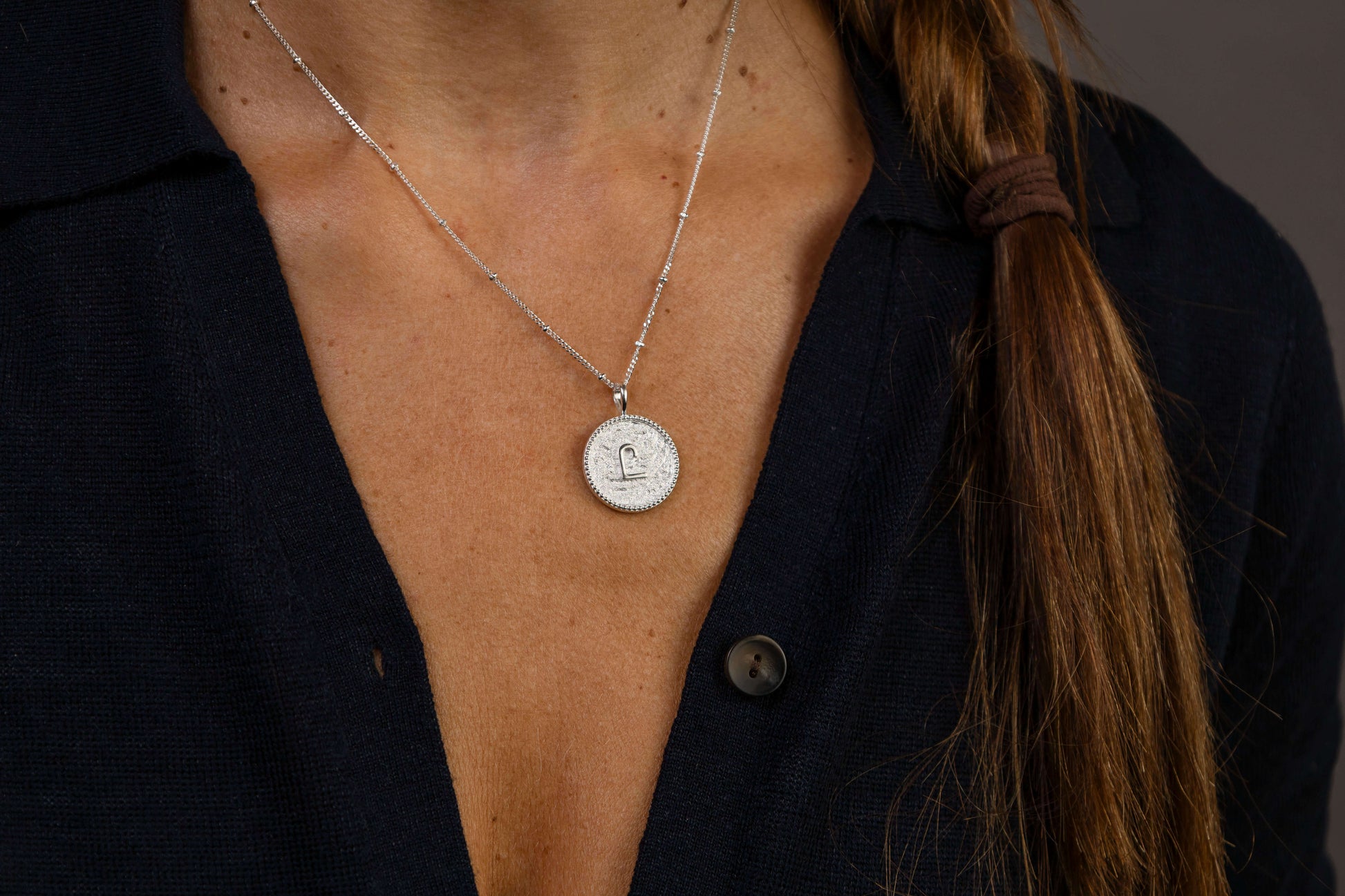 close up of women wearing C*** Silver Shorthand Coin Necklace
