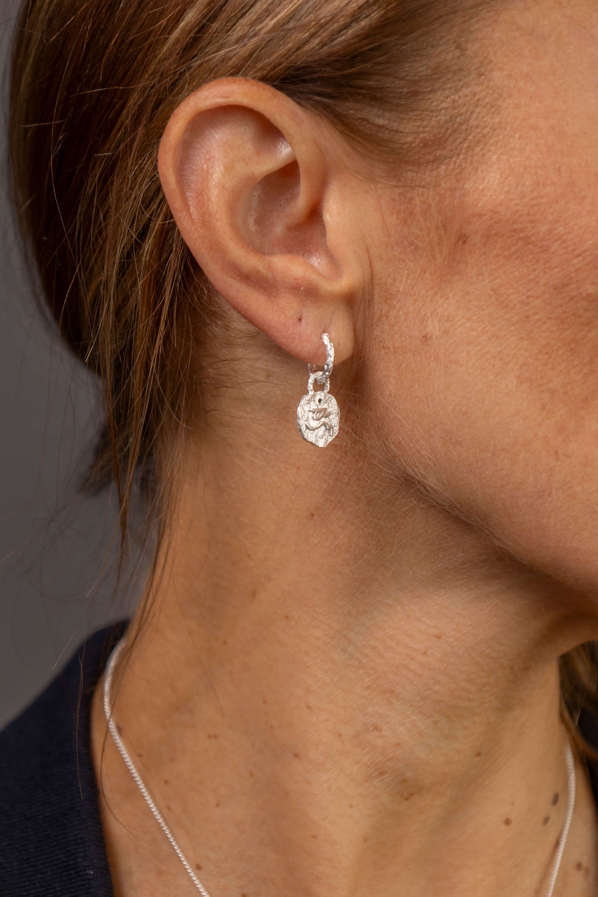 model wears Difficult Woman Silver Huggie Hoops
