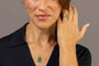 A close-up lifestyle shot of a woman wearing a gold necklace with a green chalcedony gemstone which reads F*** this S*** in Shorthand and matching ring which says Know Your Worth 