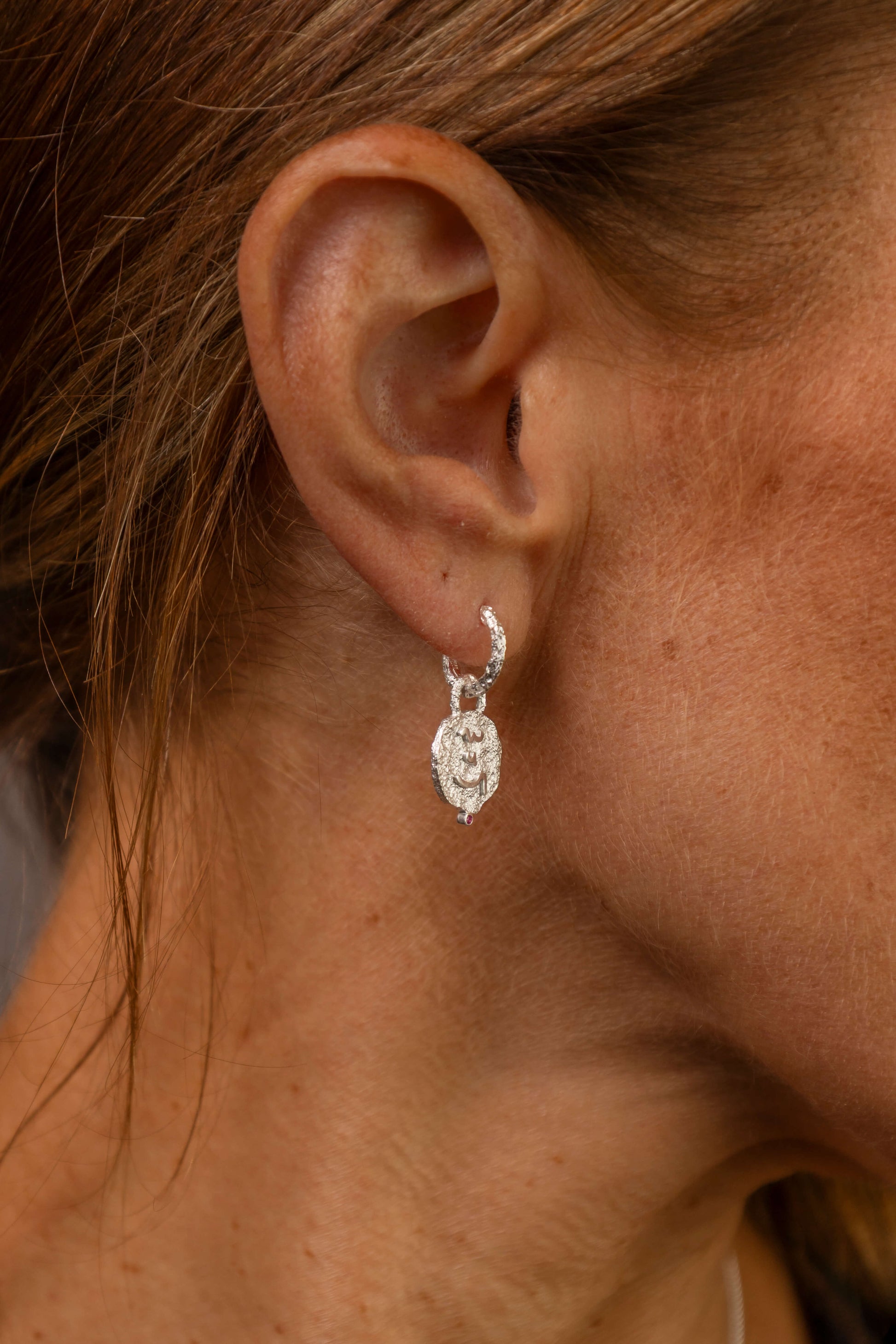 model wears Know Your Worth Silver Huggie Hoops side view 