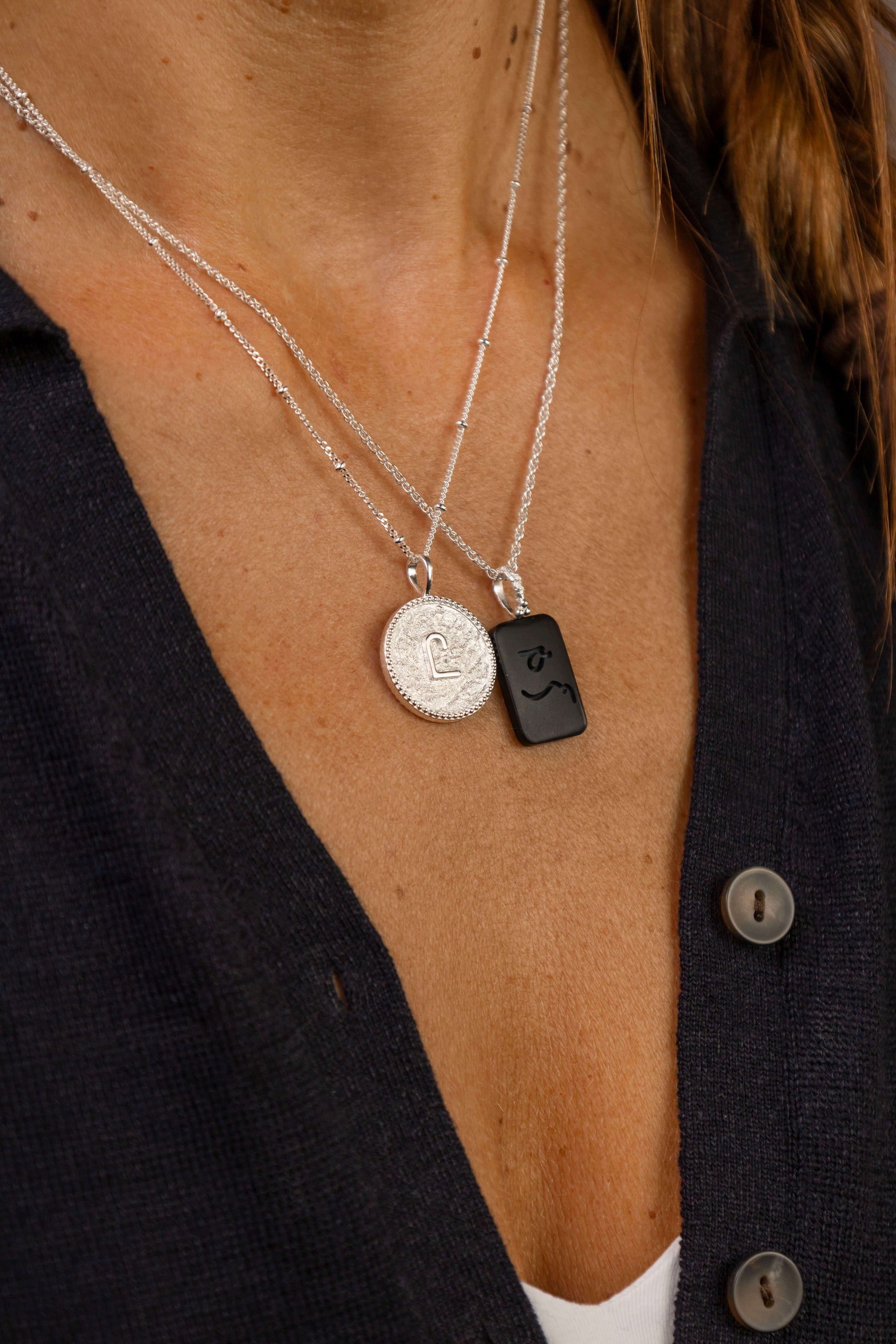 women wears C*** Silver Shorthand Coin Necklace and difficult woman onyx gemstone necklace